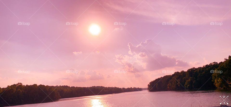 Beautiful pink sky with clouds on the water