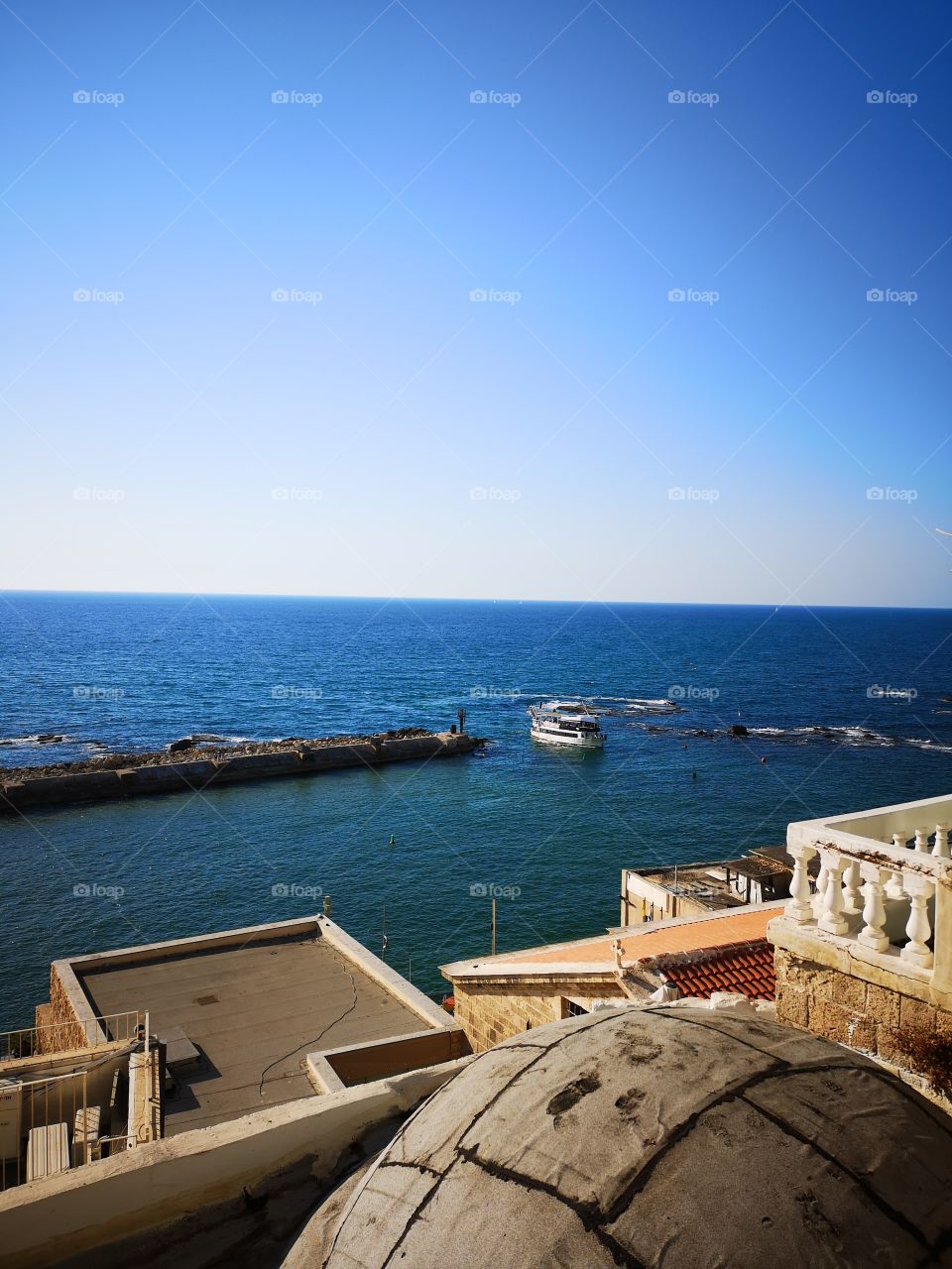 A pleasure boat enters the port of Jaffa past the Andromeda cliff