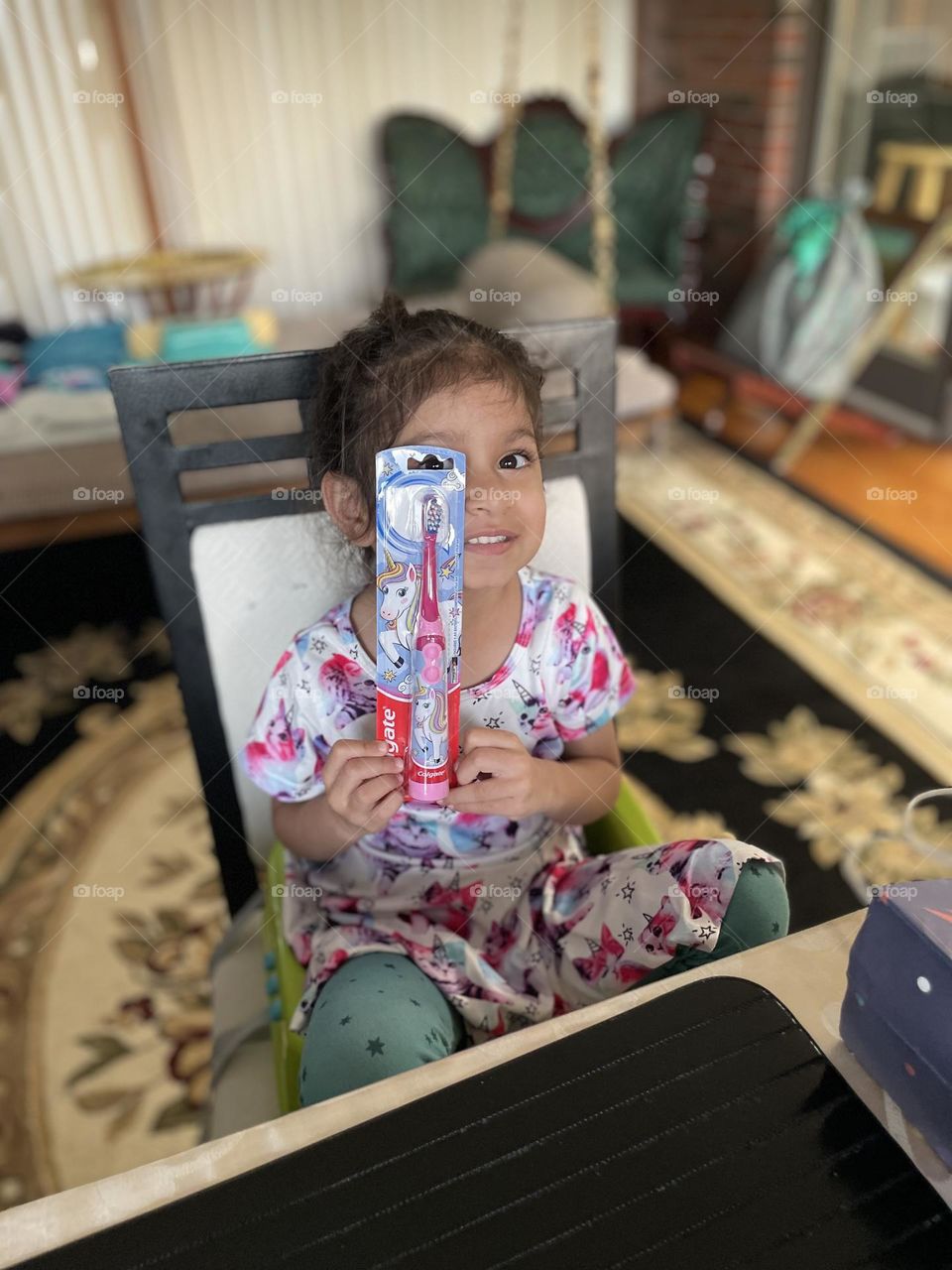 Little girl poses with toothbrush, girl receives toothbrush for gift, Colgate toothbrush for a birthday gift 