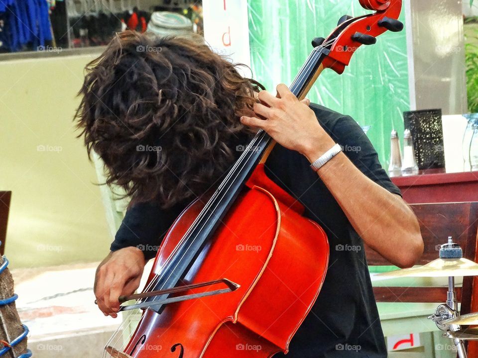 Street Musician. Musician Playing The Cello On Streets Of Cancún Mexico
