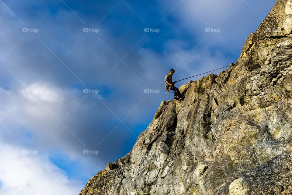 Climbing the top the top of a mountain with ropes and clever foot work
