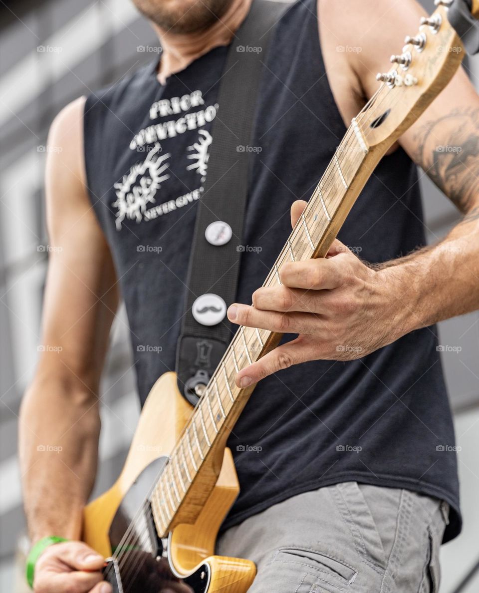 Man playing a guitar at a punk rock show 