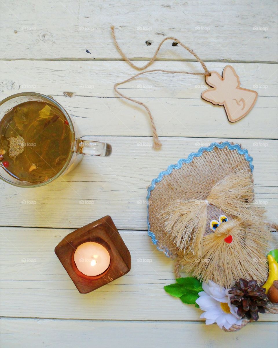 cup of tea, crafts, candle and an angel on the table