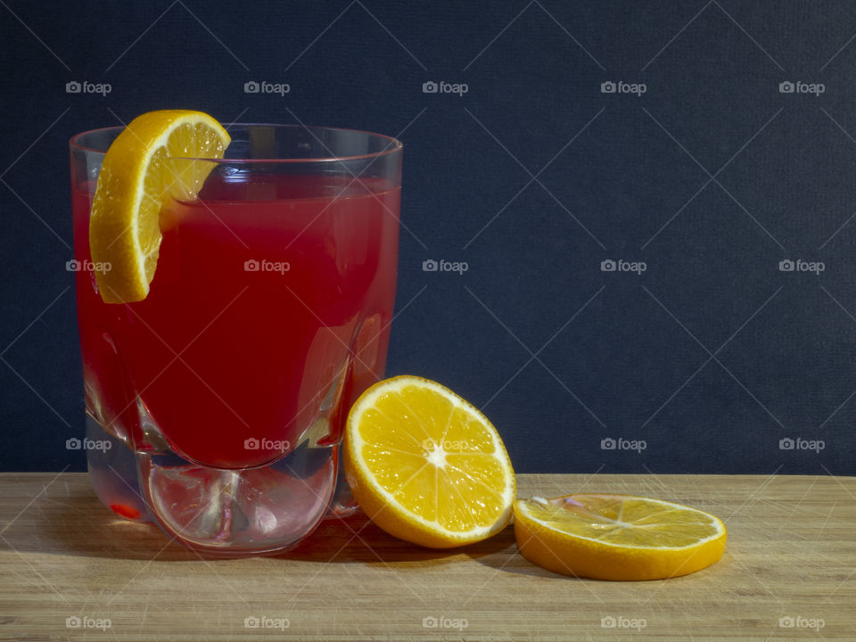 Citrus juice with lemon slices on dark background