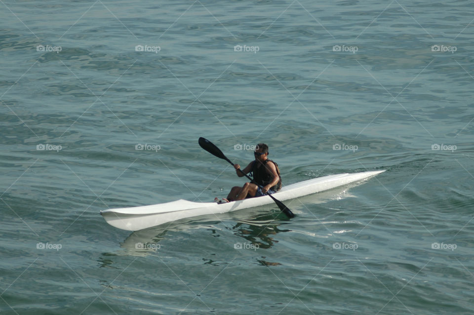 A man kayaking in the Pacific ocean.