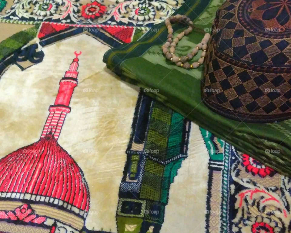 Cap and sarong on prayer rug