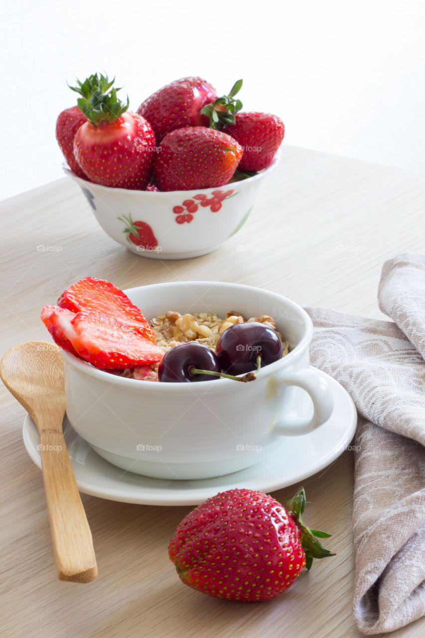 Oats, strawberries and cherry in cup