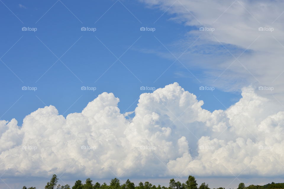 Puffy clouds over field