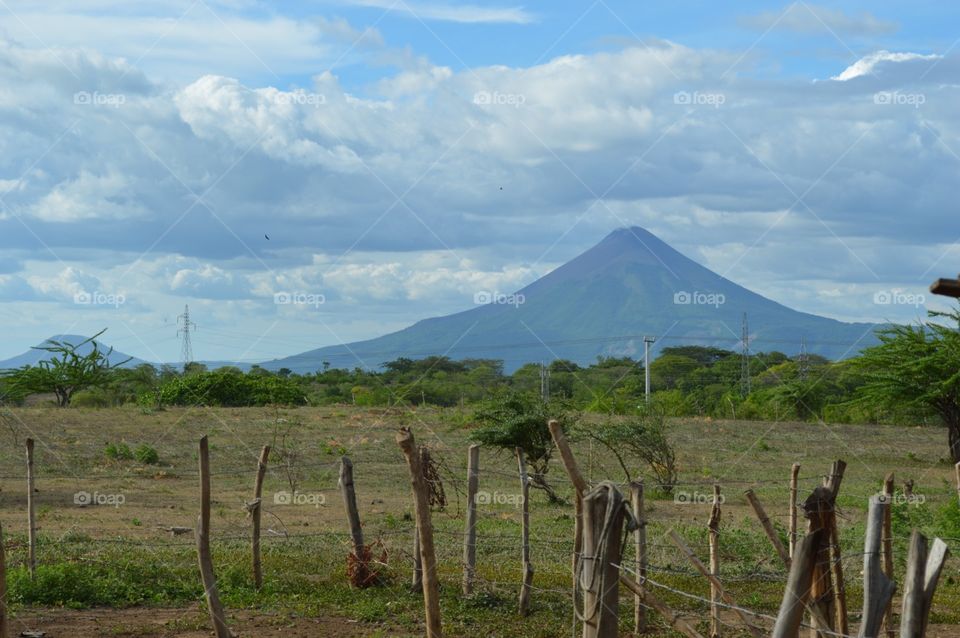 Typical Nicaraguan Backyard . Taken in a village in Nicaragua. This is a volcano, not a mountain.