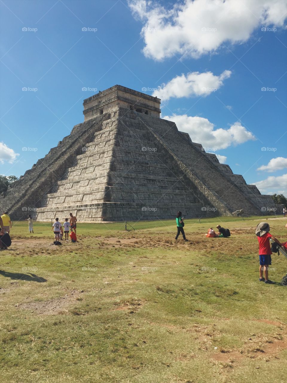 A rare image of Chichen Itza, the famous Mayan Ruin, featuring sunny blue skies and minimal tourists in the shot.