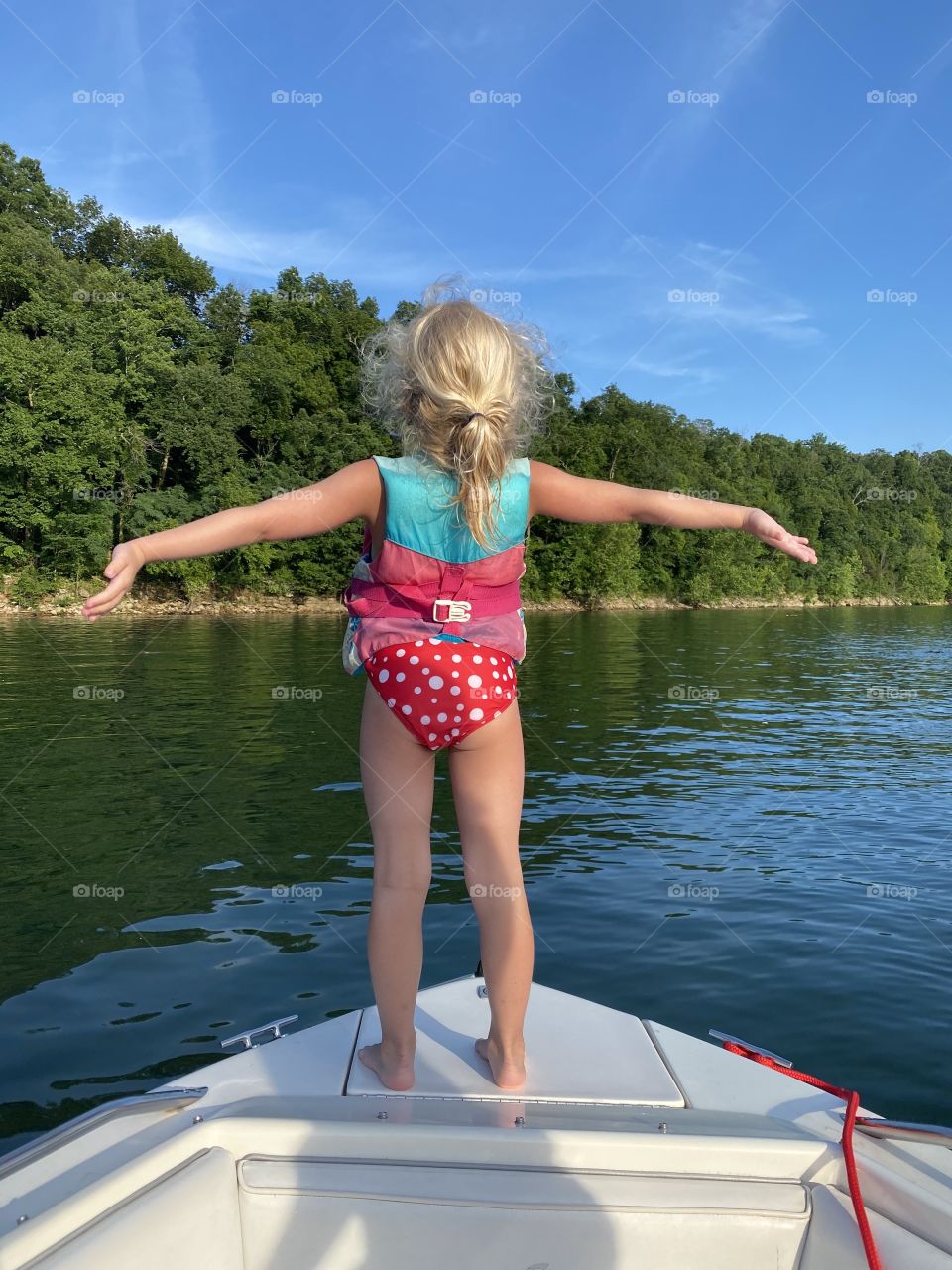 Cute kiddo living her best life on a boat on a beautiful summer day 