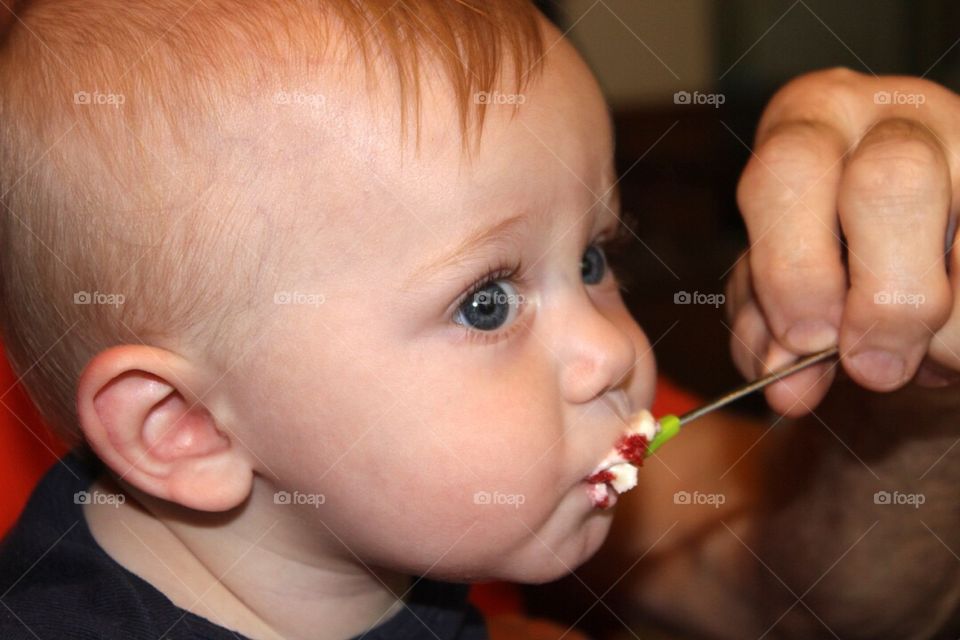 Close-up of a person's hand feeding baby