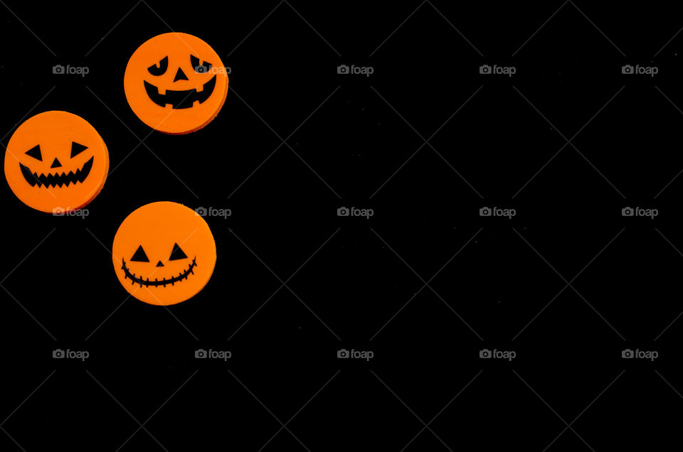 A Halloween symbol. Three variants of Jack-faced pumpkins. Orange and black colors, minimalism, high contrast.