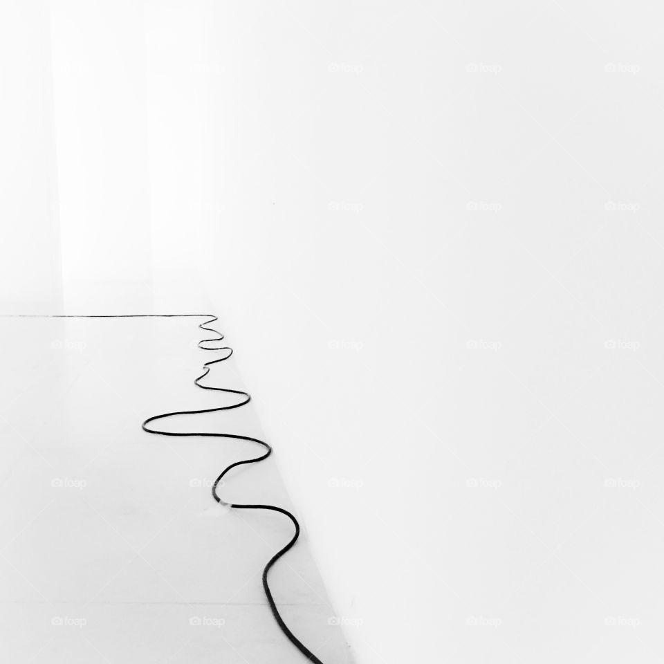 Black wire in white colored interior room