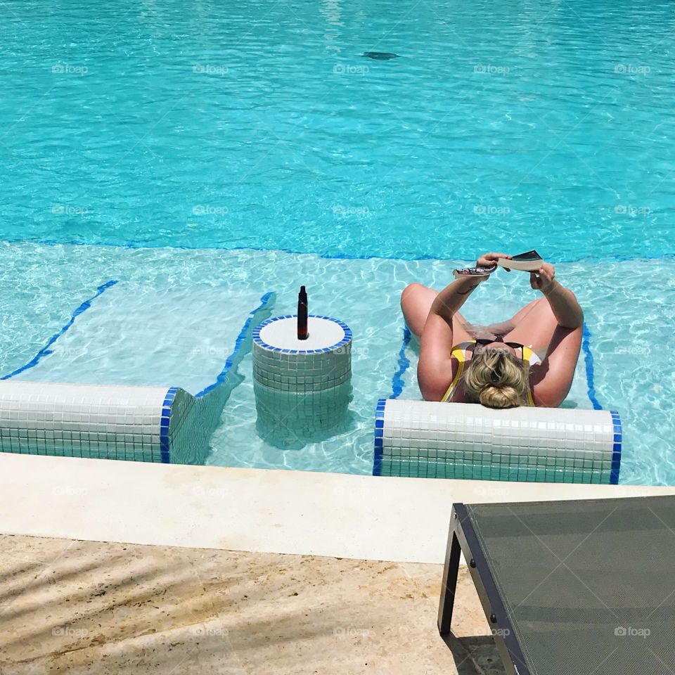 Relaxing & reading in the tranquil pool on Caribbean holiday 