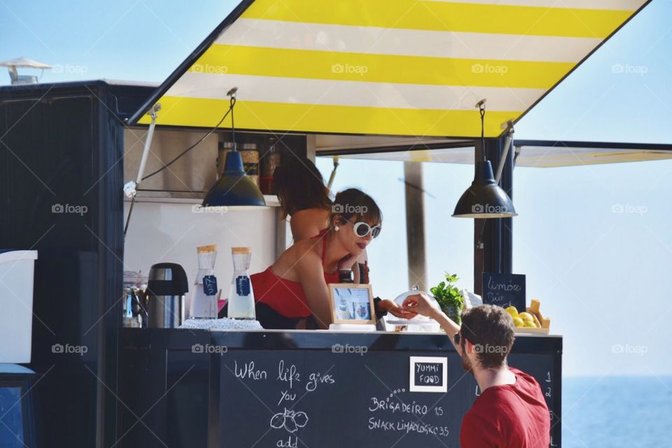 Young lady selling organic lemonade 