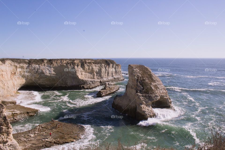 High vantage point landscape view from an overlooking cliff of Sharktooth Beach in Davenport, California on a clear, bright sunny day