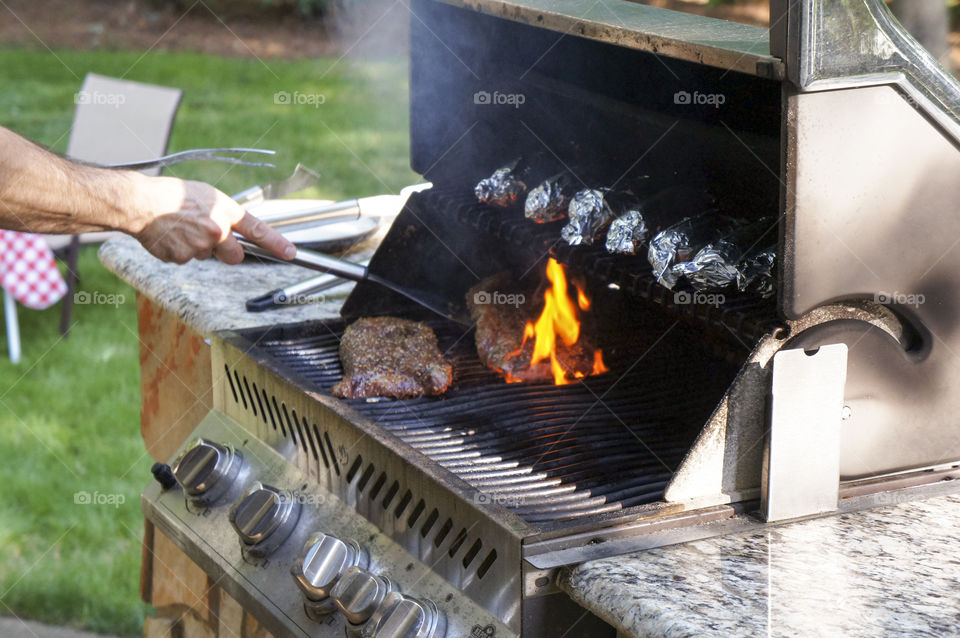 Cooking meat on barbecue at backyard