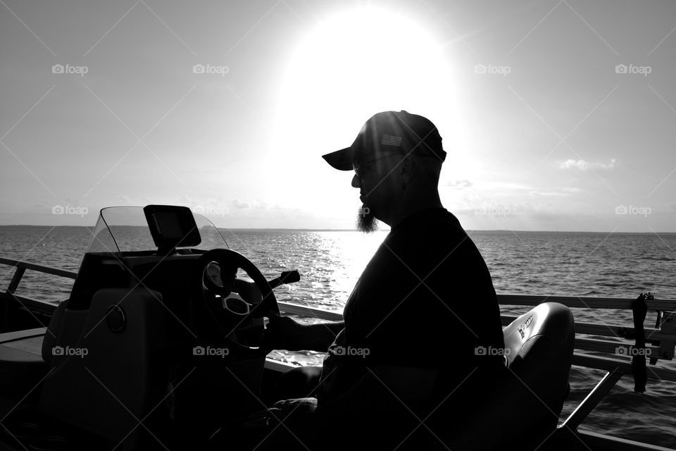 Silhouett of my husband driving our boat on lake Livingston Texas 