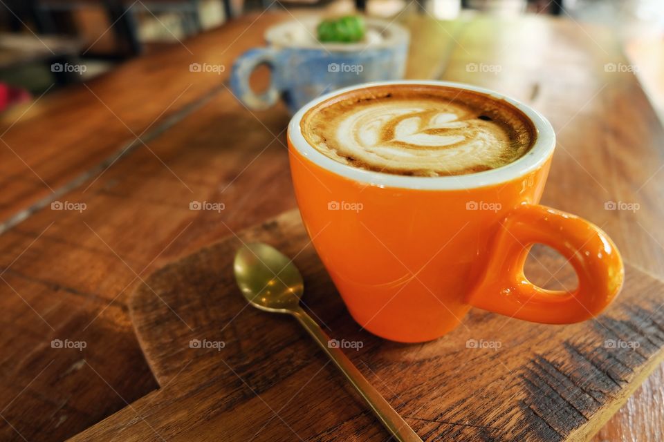 Cappuccino and spoon on cutting board