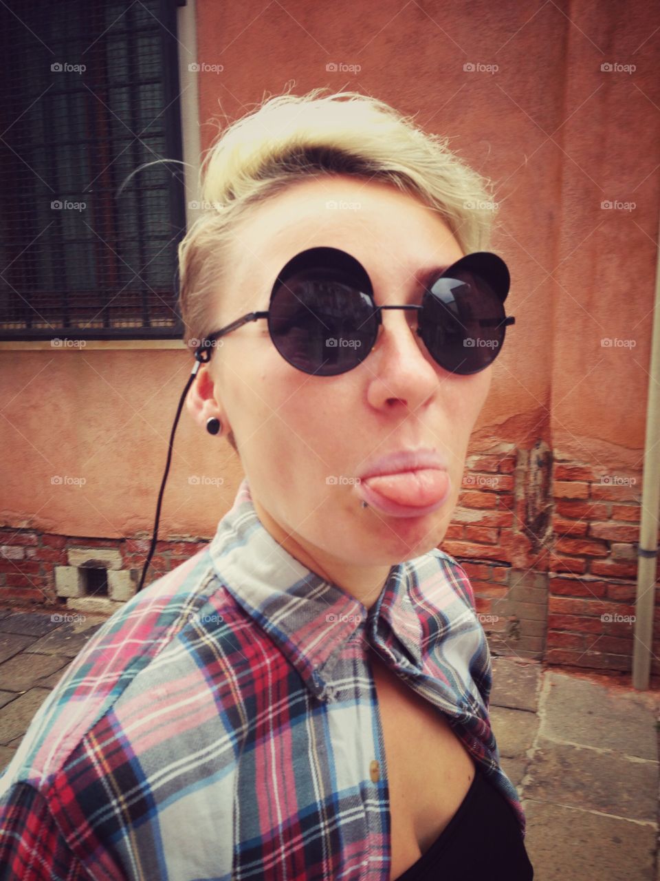 Young woman showing her tongue)
