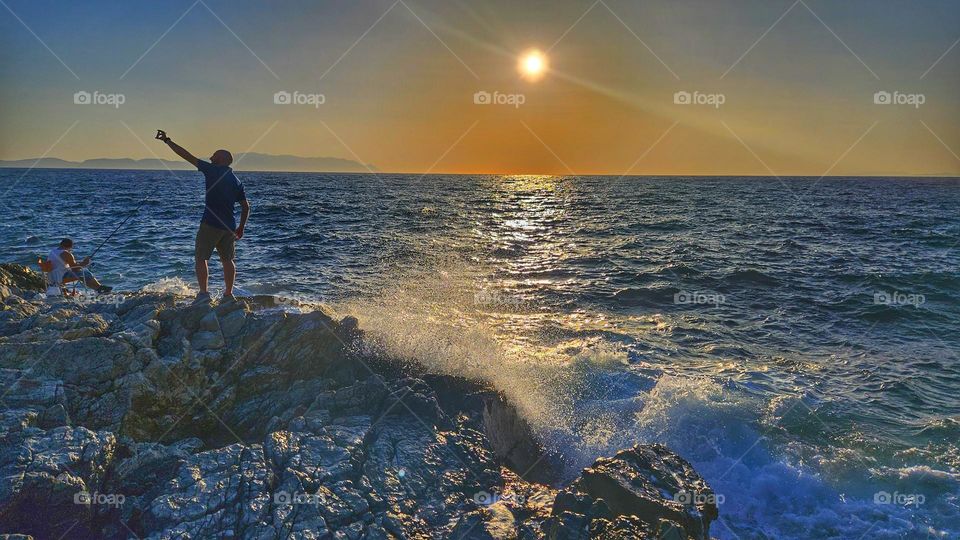 selfie at sunset on the stones by the sea