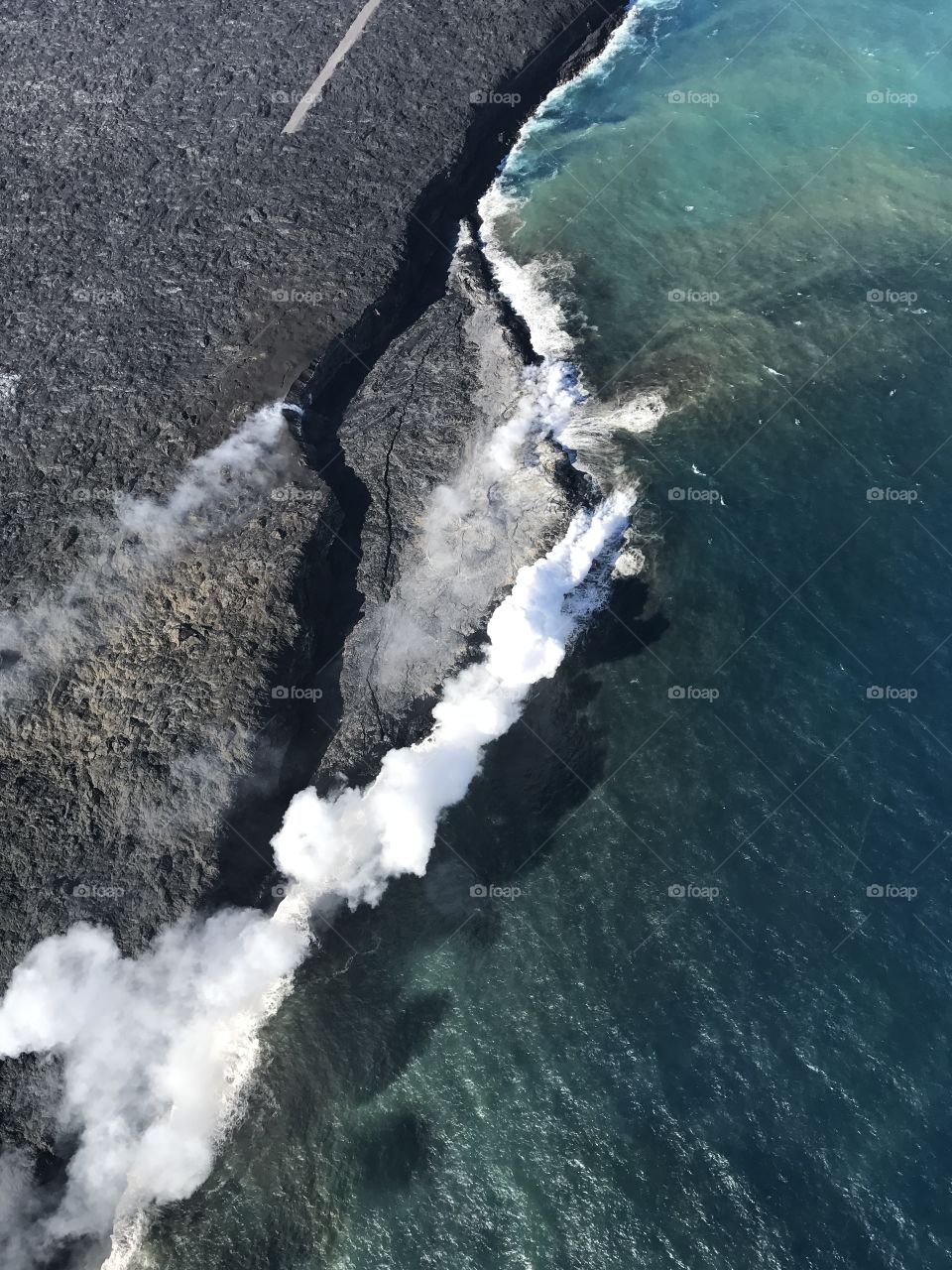 A volcano on the big island in Hawaii continuously spewing hot lava into the ocean. 