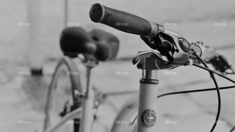 Black and white closeup crop view of bicycle handlebars seat frame tire