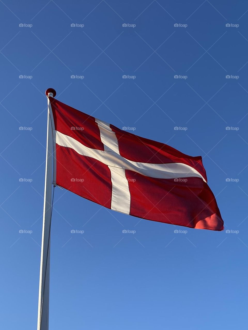 flag of Denmark in the wind and beautiful blue sky 