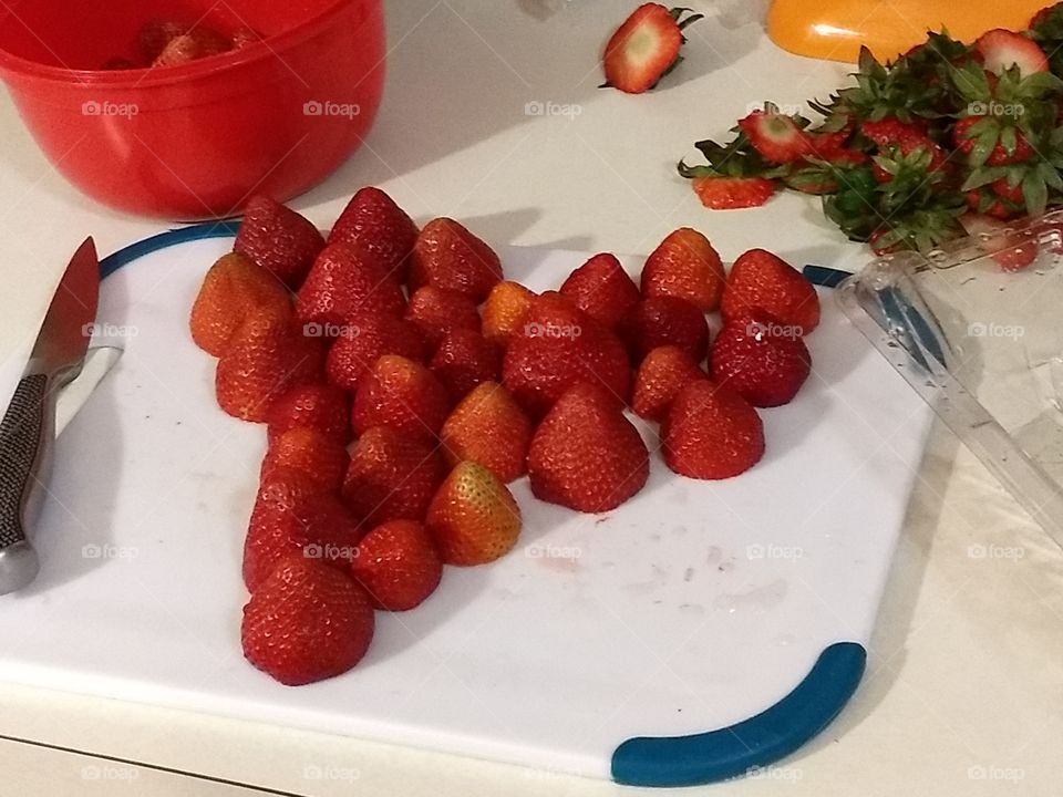 strawberries in shape of heart on cutting board