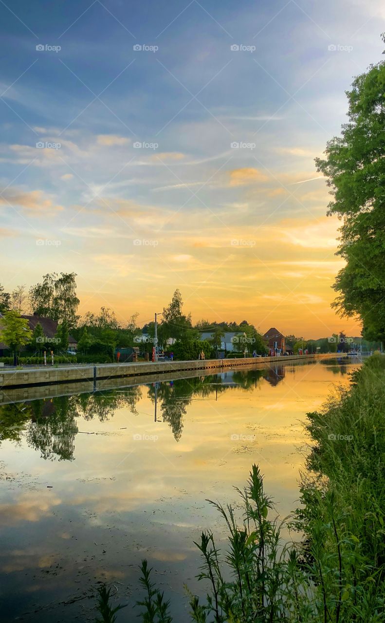 Golden sunset sky over a river Countryside landscape reflected on the surface of the water