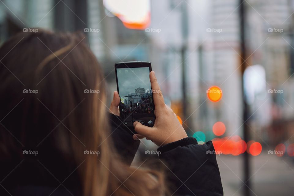 A young woman using her phone on the go