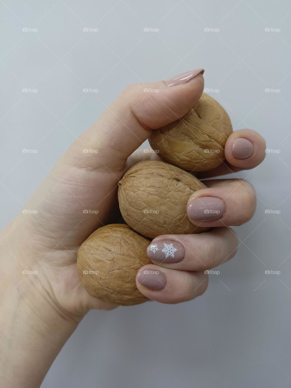 manicure on hands, female hand, color of coffee with milk, snowflake on nails, white background, walnut