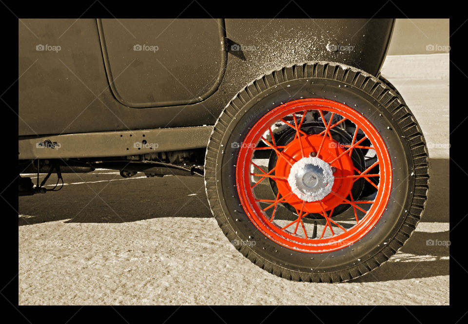the back tire of a classic Ford sitting on the bed of the Bonneville Salt Flats diuring Speed Week