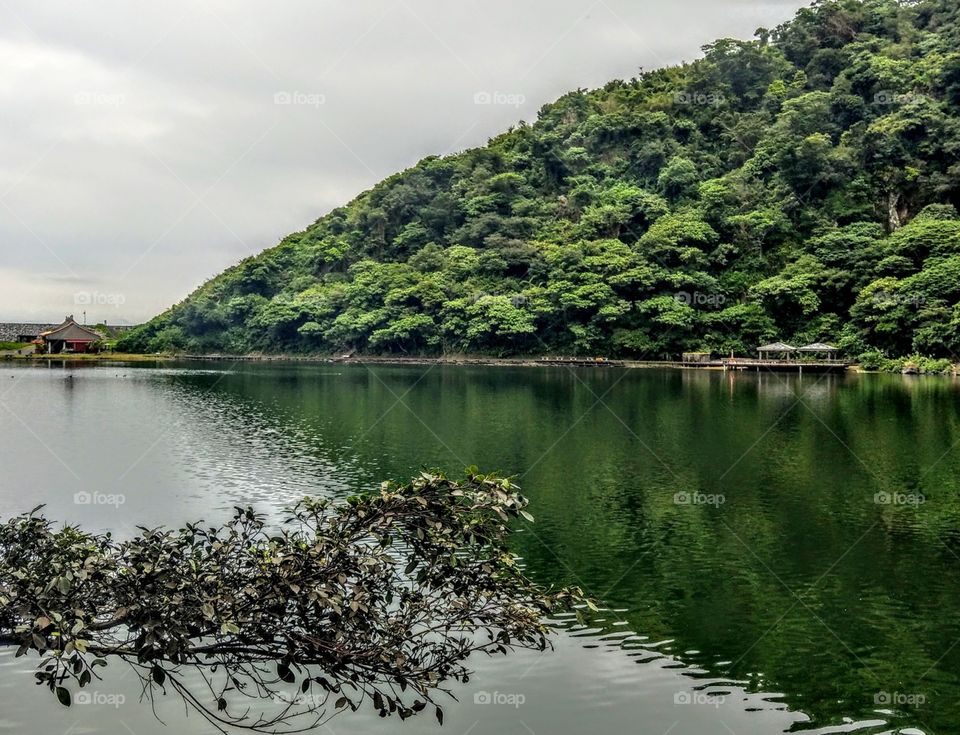 The mountain reflection into the lake that is in the the Turtle Island. beautiful lake, green mountain and special pavilion.