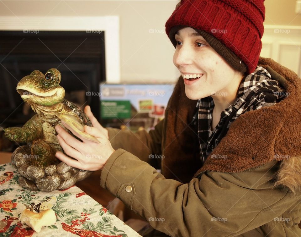 A young lady surprised and joyful with her Christmas present. 