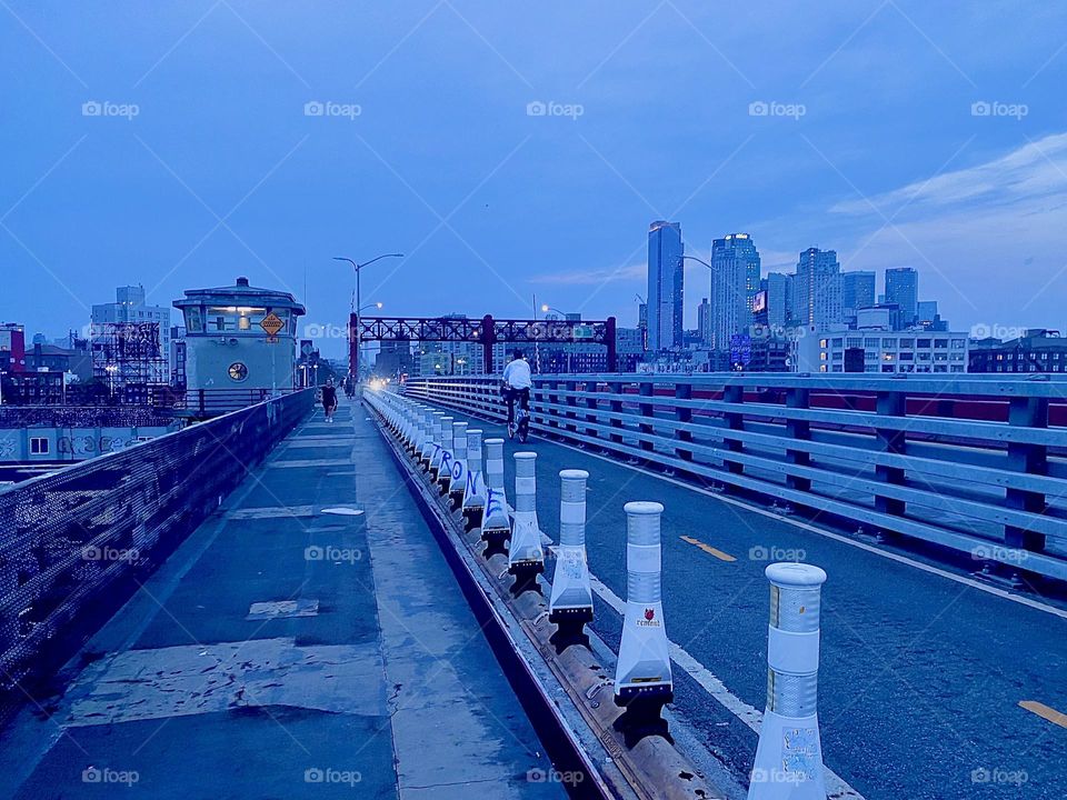This is the pedestrian lane of the “Pulaski Bridge” at “Newtown Creek” with the bicycle lane and car lanes to the right crossing over to LIC, Queens from “Greenpoint”, Brooklyn on a warm balmy evening in September 2023. Hypnotic Productions