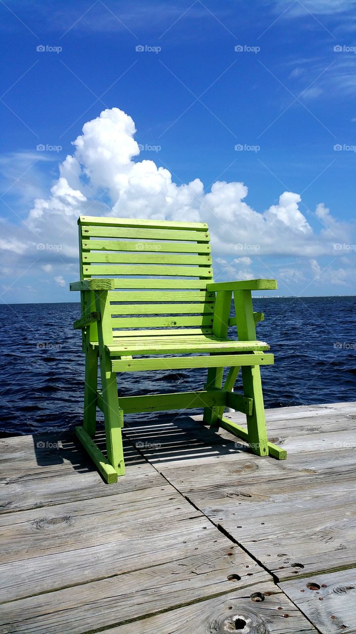 Green chair on wooden in sea