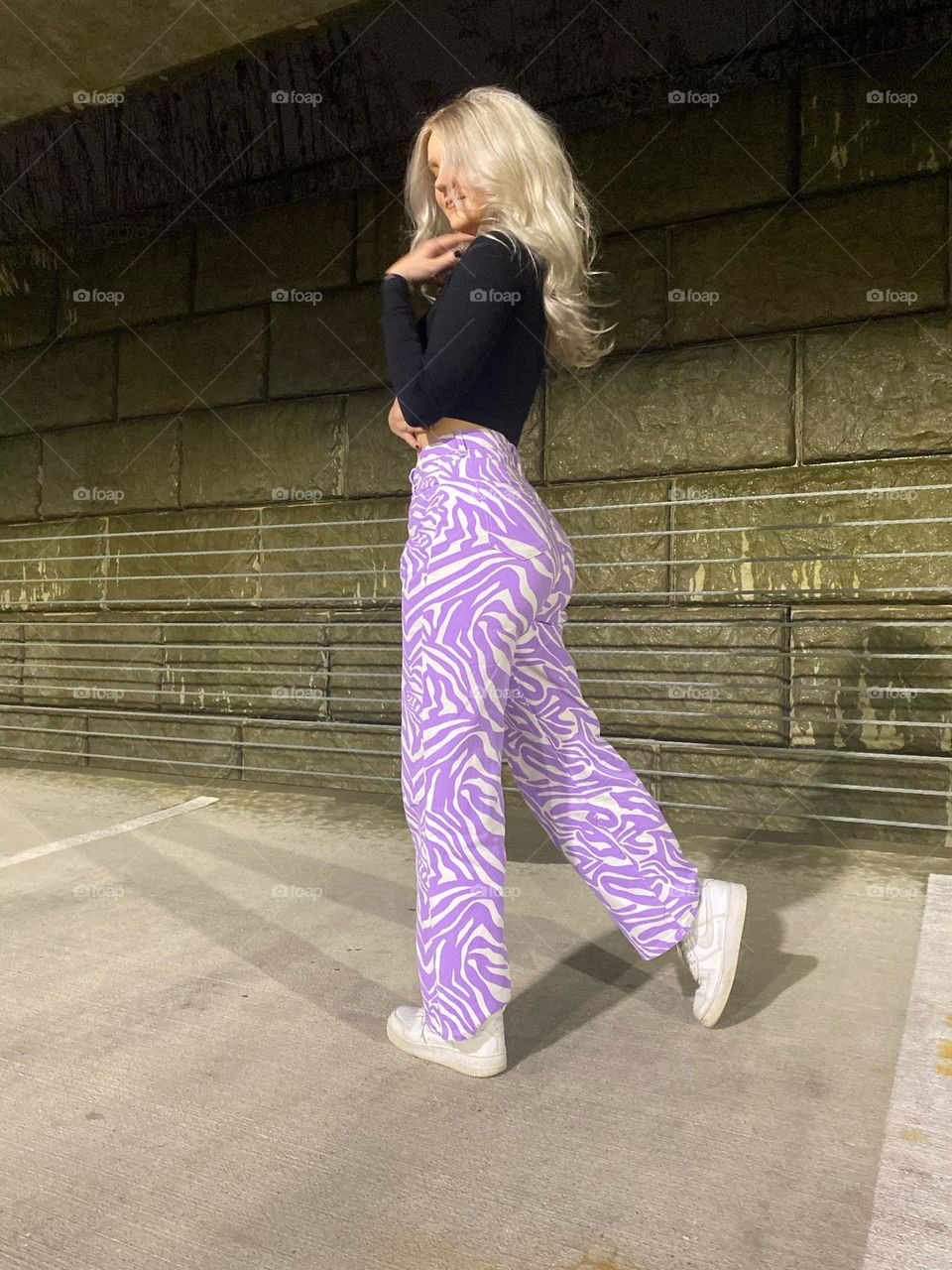 Blonde girl with funky purple and white pants in urban setting 