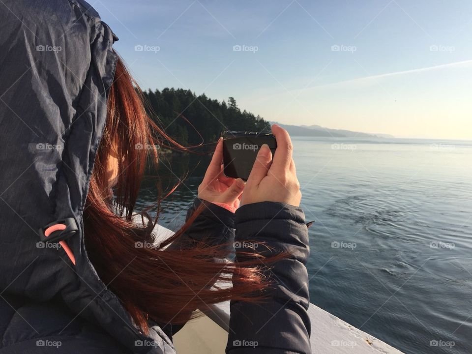 Girl taking photo on ferry 