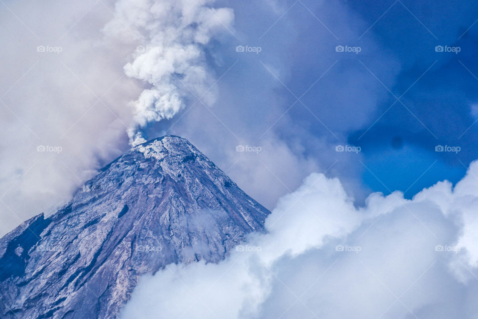 Mayon Volcano one of the 8 wonders of the world a volcano with a perfect cone. An image of the volcano spewing smoke and ash during eruption
