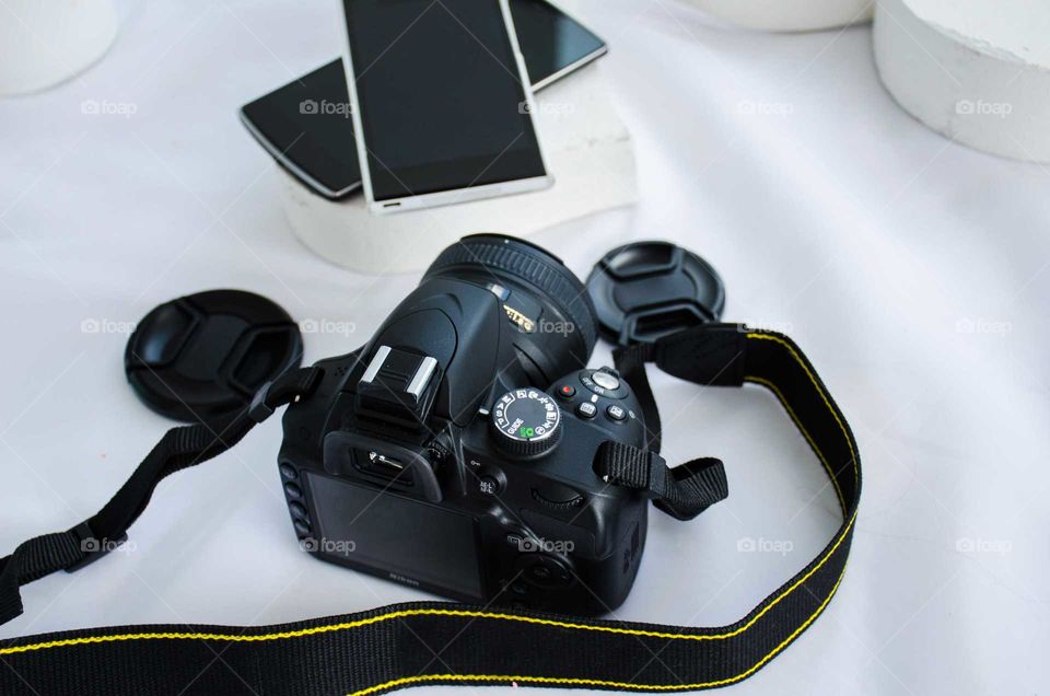 DSLR camera with smartphones on white background