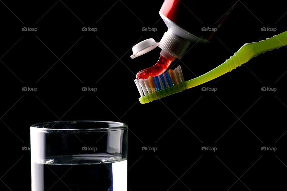 toothbrush, toothpaste and glass of water