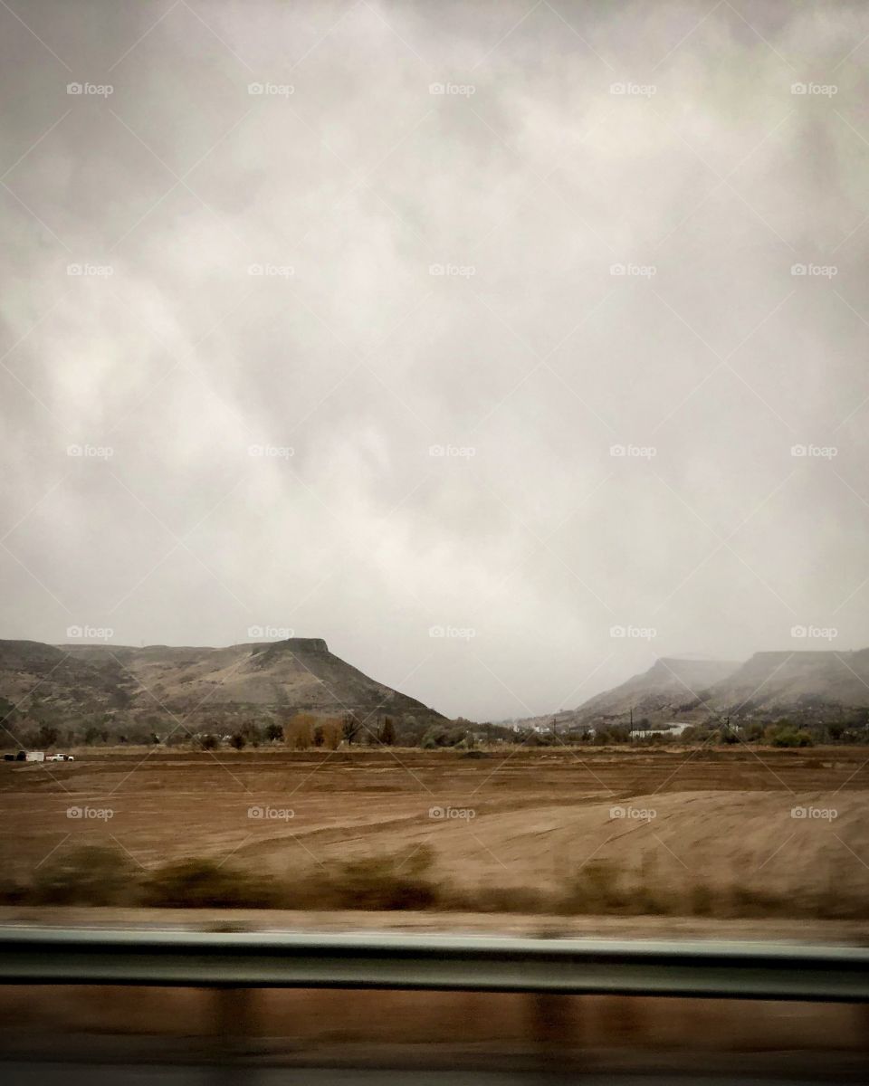 Driving through the brown fields to the mountains.