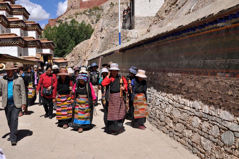 ceremony in buddhist monastery - tibetan men and women making kora around mortar