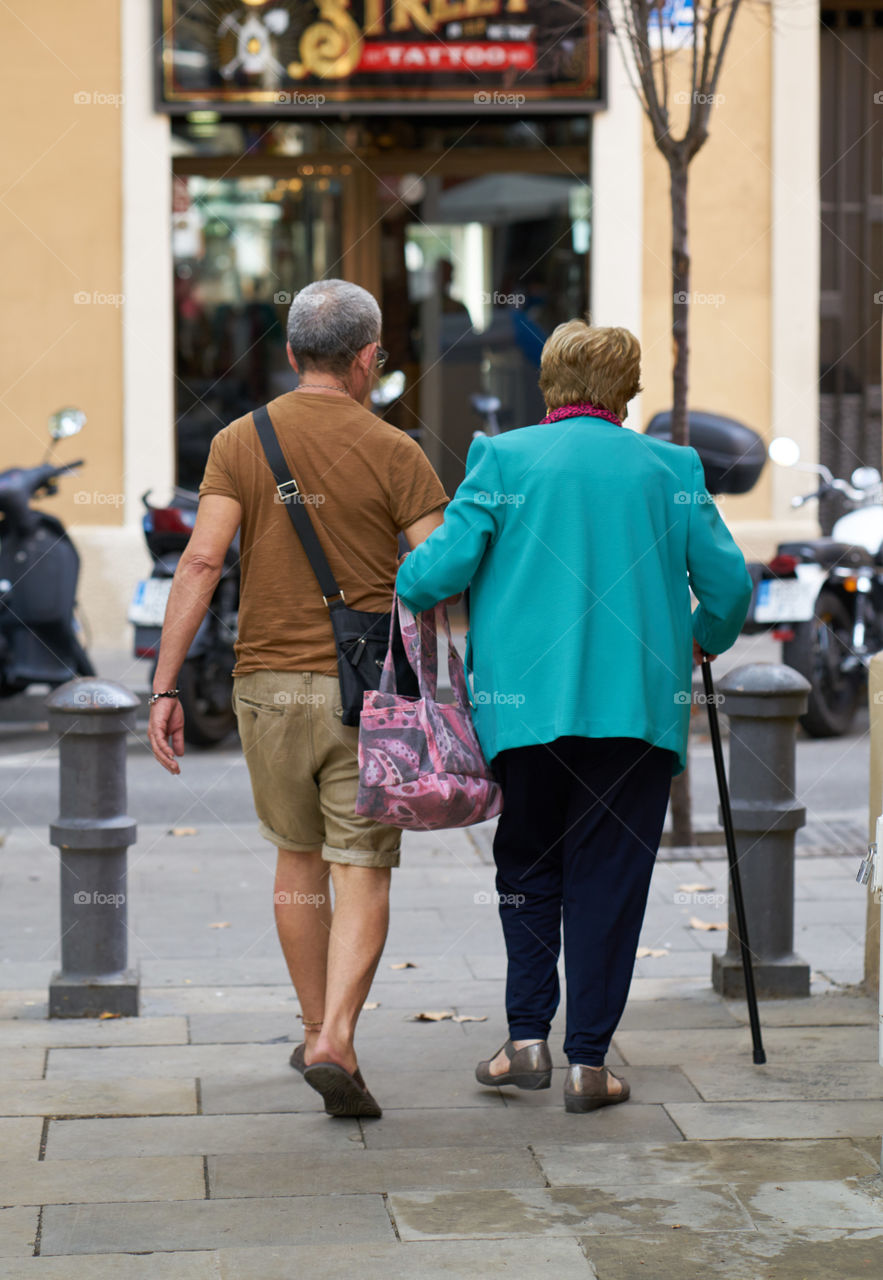 Elderly woman helped by her assistant