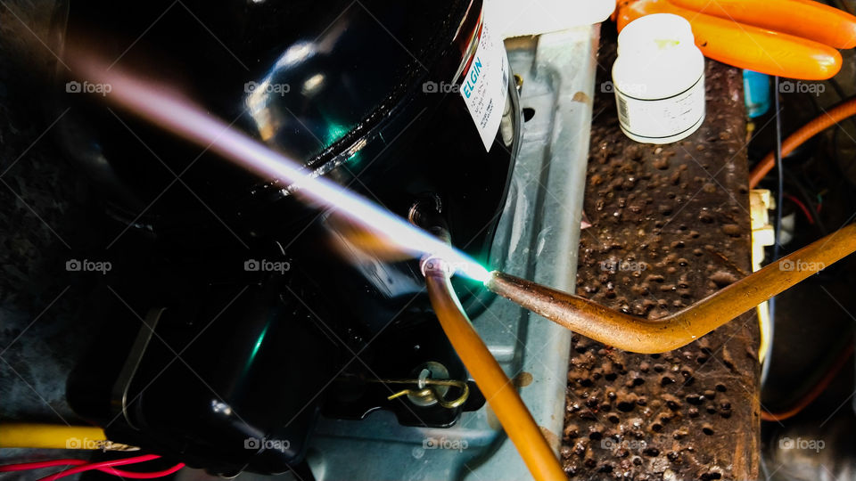 Fogo de maçarico. Solda em motor de geladeira.