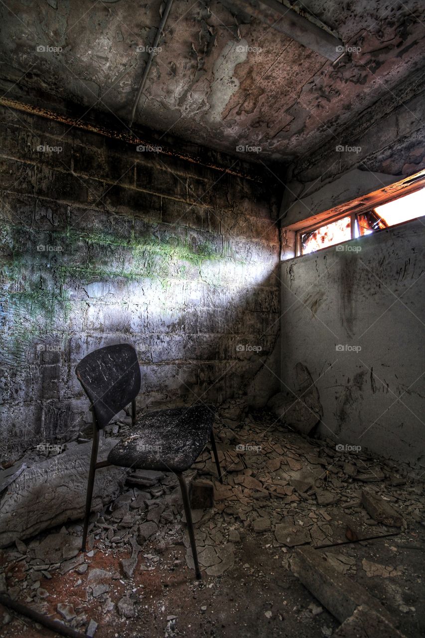 A single, small window lights a derelict room.