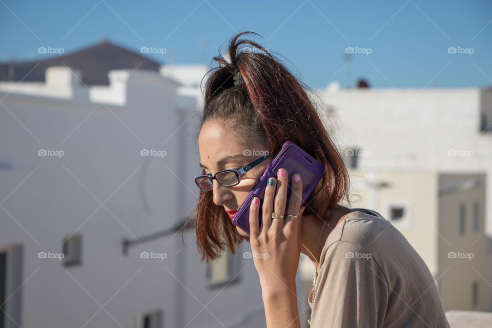 Girl talking on the mobile phone on the rooftop 