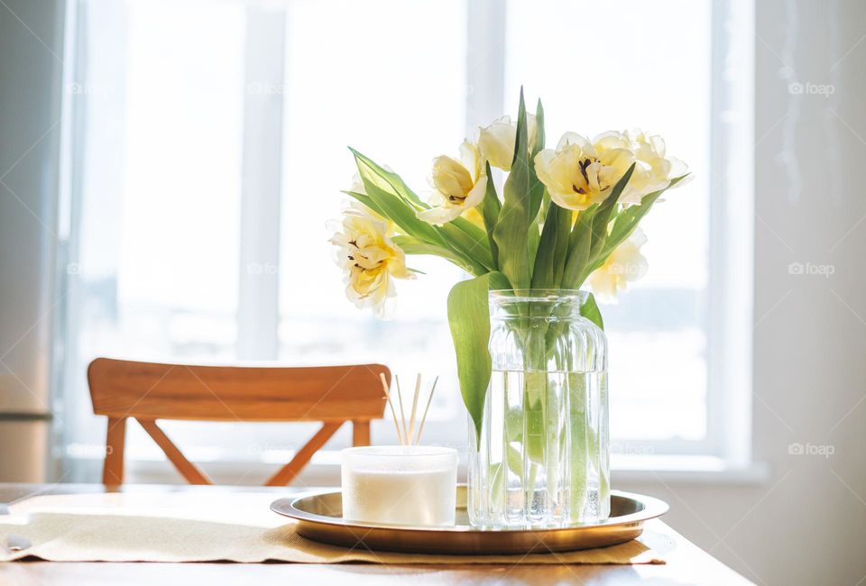 Bouquet of flowers tulips in vase on table at home 